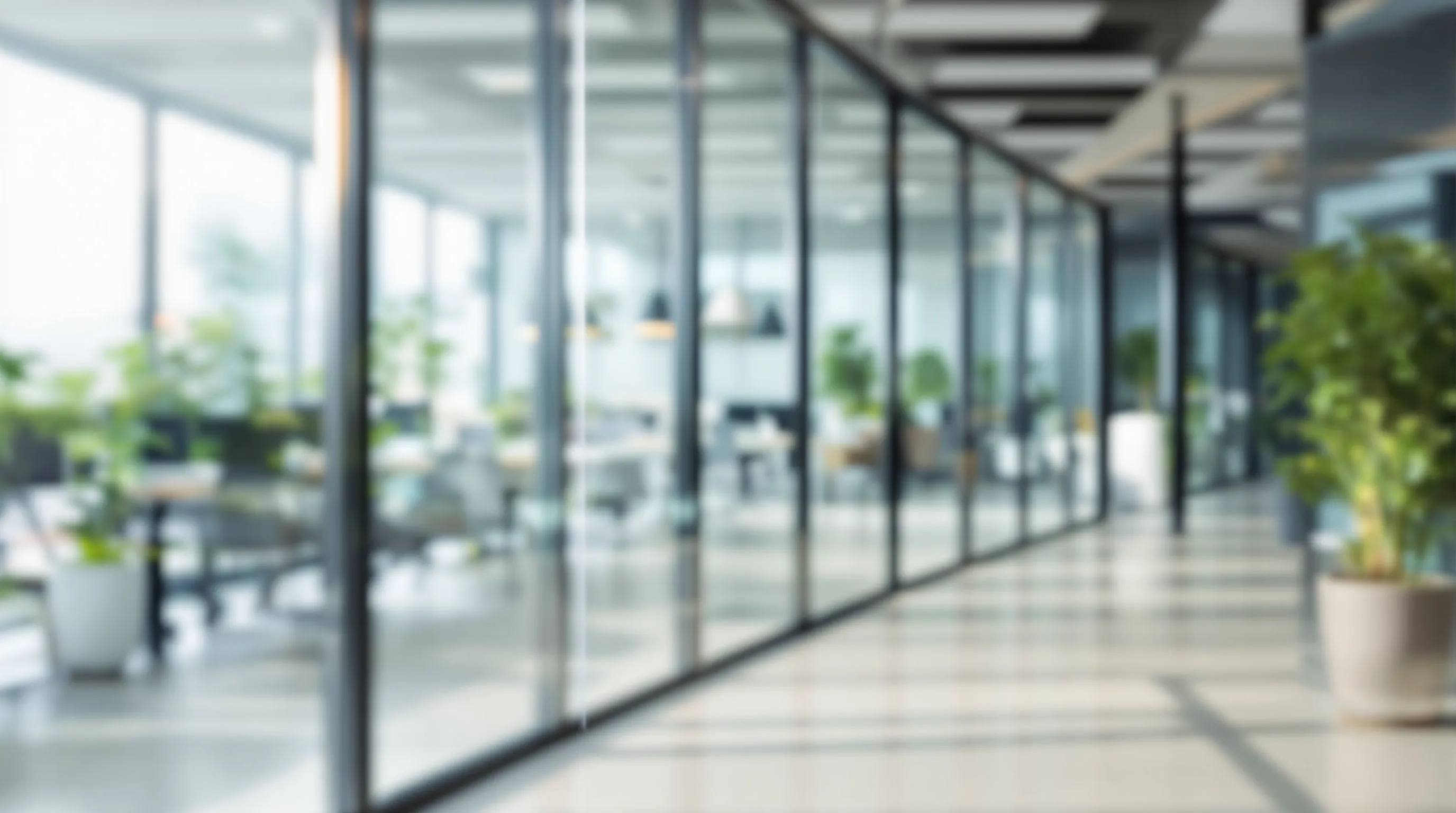 Example image: Modern minimalist office space with glass walls, soft natural light from left, blurred background